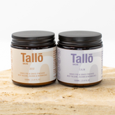 Two jars of Talló skin products on a wooden surface with a white background