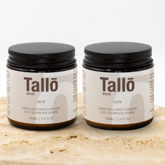 Two jars of Talló Skin on a wooden surface
