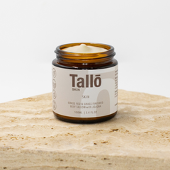 Jar of Tallo skincare product on a wooden surface with a white background