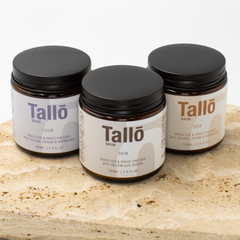 Three jars of Tallo skin care products on a stone surface