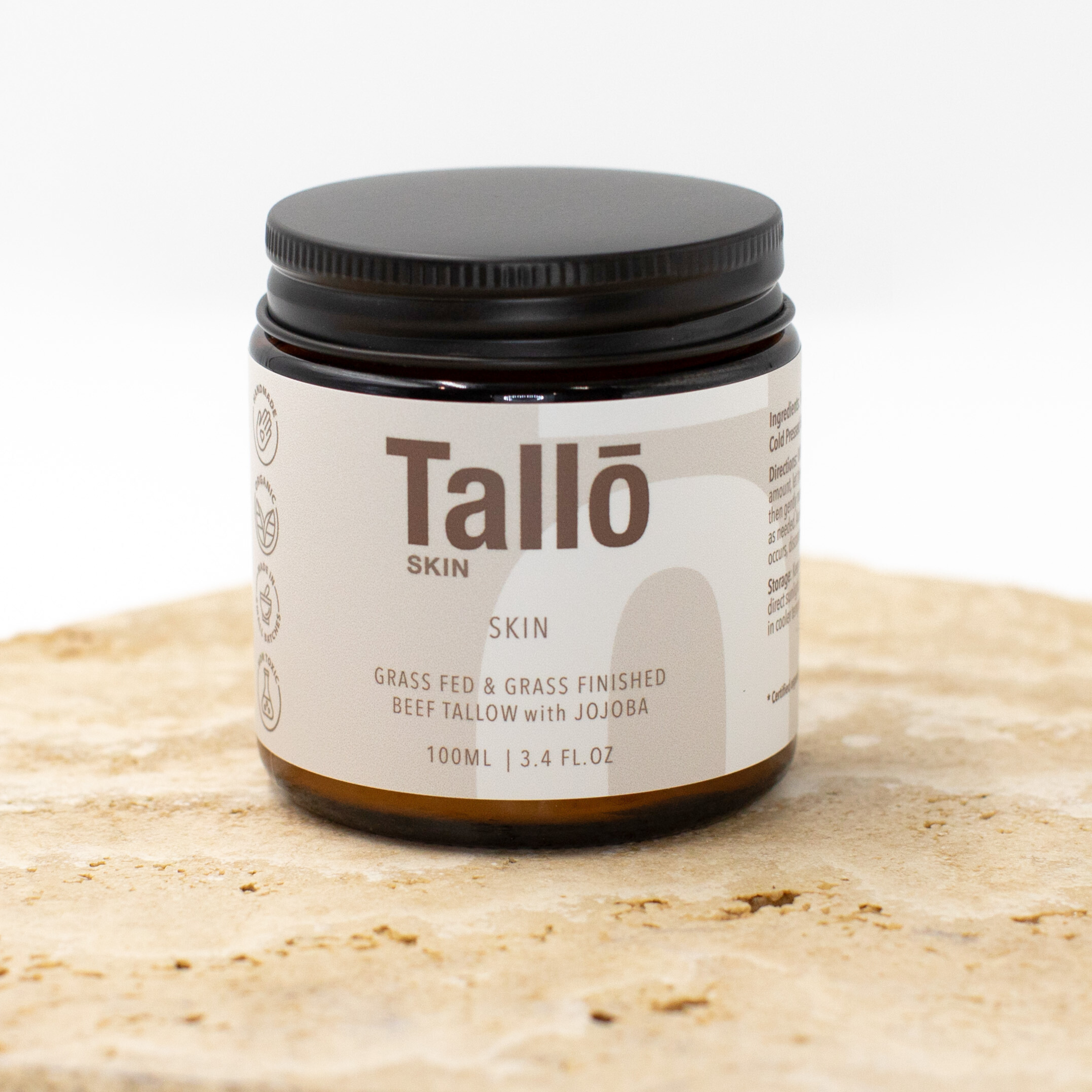 Jar of Tallow Skincare on a textured surface with a white background