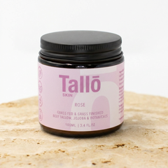 Jar of Tallo Skin cream with a pink label on a light brown surface