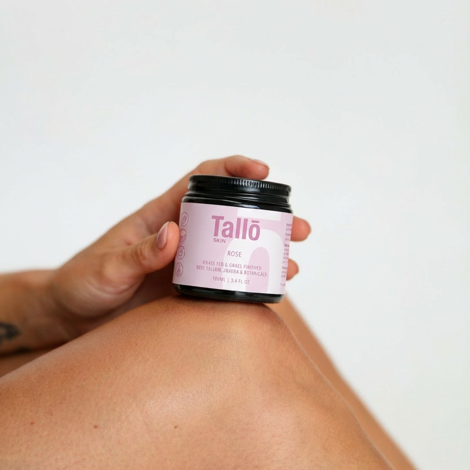 Person applying Tallo cream to their shoulder with a white background